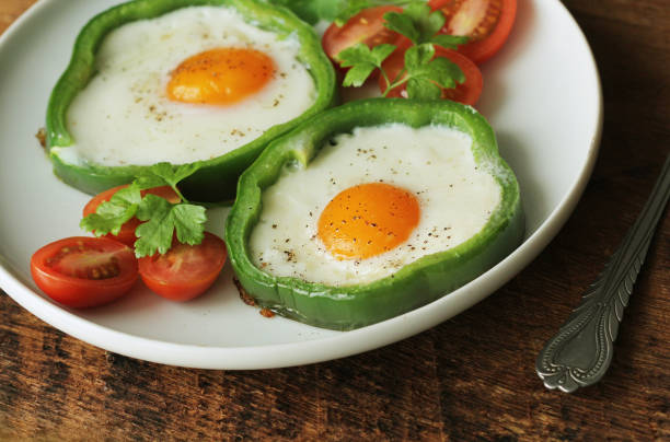Fried egg in the ring of the bell peppers with herbs stock photo