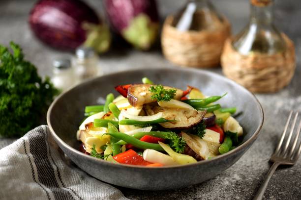 Fried eggplant salad with mozzarella, bell peppers, onions and green beans. stock photo