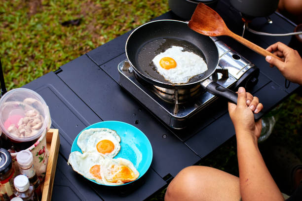 Fried eggs for breakfast while camping and outdoor picnic stock photo