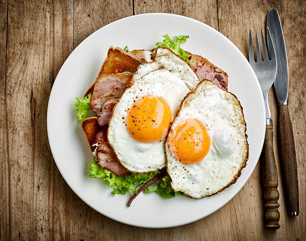 fried eggs on white plate plate of fried eggs and bacon on white plate, top view fried egg photos stock pictures, royalty-free photos & images