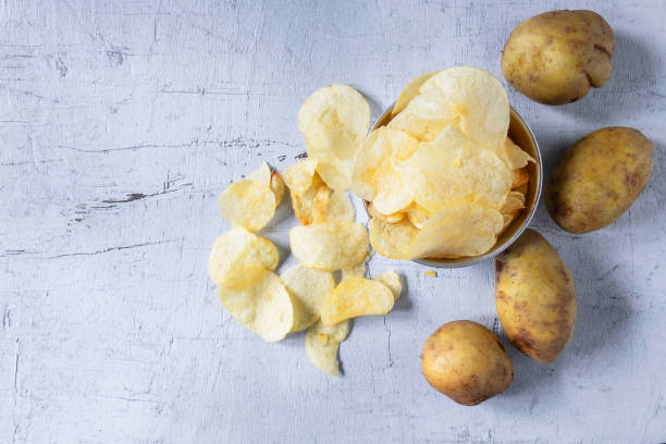 Fried potato chips In a bowl on white background stock photo