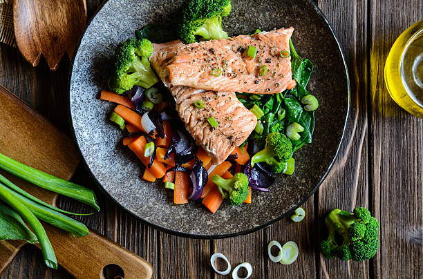 Fried salmon with steamed vegetable Fried salmon steaks with steamed carrot, broccoli, onion and spinach salmon seafood photos stock pictures, royalty-free photos & images