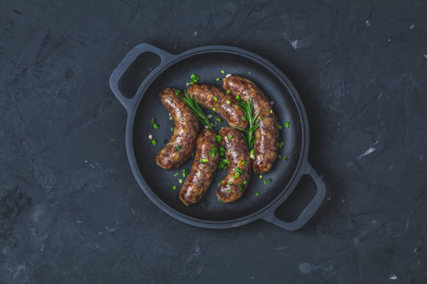 Fried sausage in a frying pan, with herbs and spices stock photo