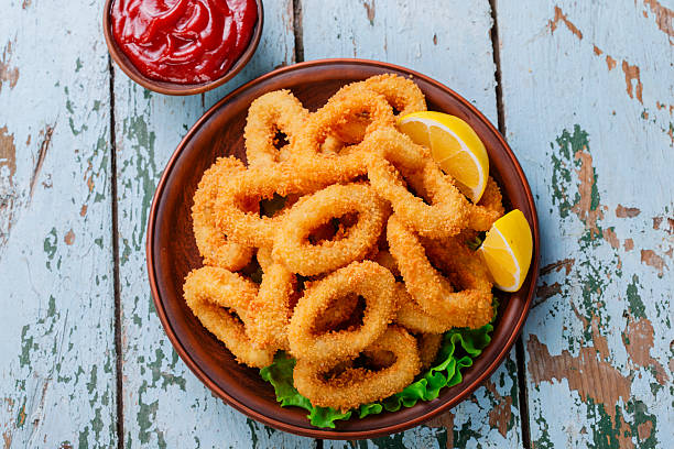 fried squid rings breaded with lemon stock photo