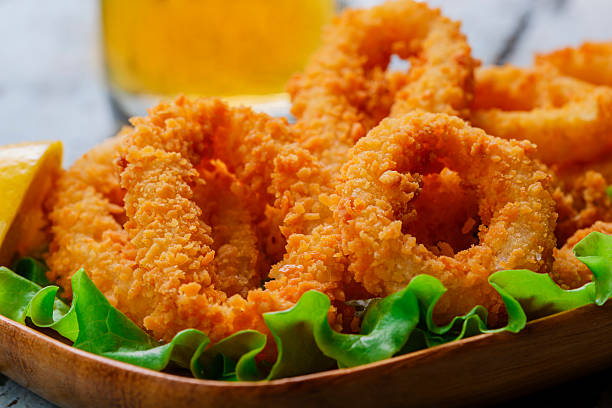 fried squid rings breaded with lemon stock photo