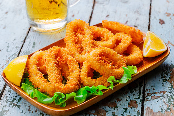 fried squid rings breaded with lemon stock photo