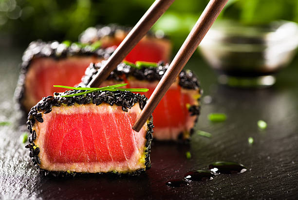 Fried tuna steak in black sesame with chopsticks stock photo