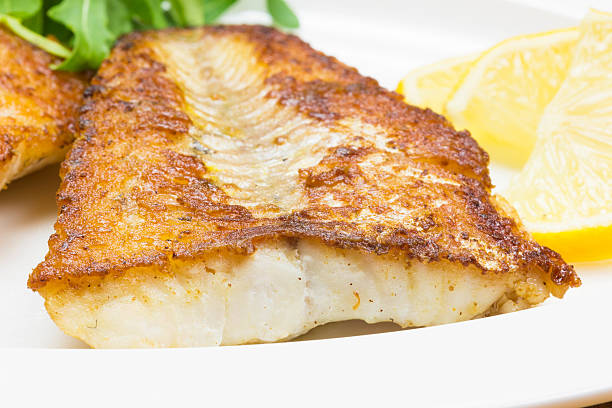 Fried white fish White fish with lemon on white plate, selective focus perch fish stock pictures, royalty-free photos & images