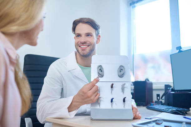 przyjazny lekarz oferujący różne pomoce głuche dla swojego pacjenta - hearing aids zdjęcia i obrazy z banku zdjęć