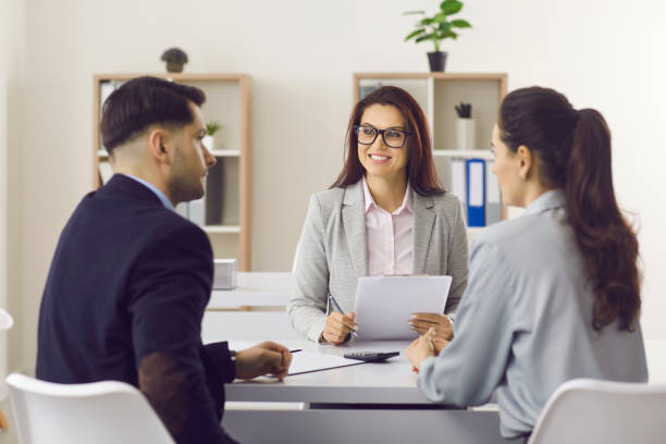 Friendly insurance manager or mortgage broker meeting with clients at her office stock photo