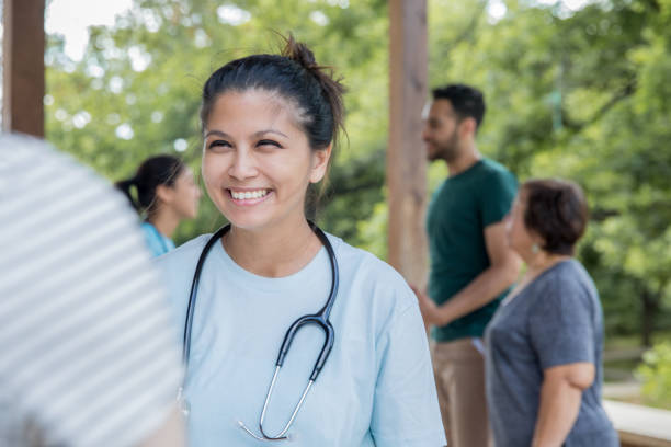 Friendly nurse helps patient during an outdoor health fair or free clinic event stock photo