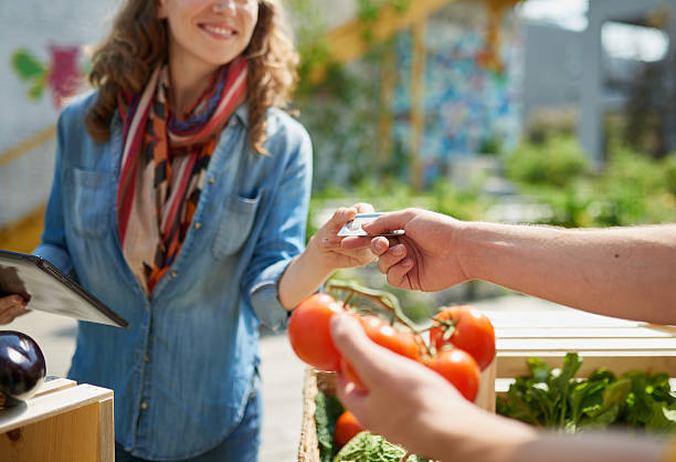Friendly woman tending an organic vegetable stall at a farmer stock photo