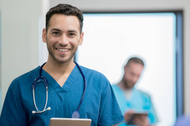 Friendly young Hispanic male doctor working in hospital emergency room Friendly young Hispanic male doctor working in hospital emergency room nurse face stock pictures, royalty-free photos & images