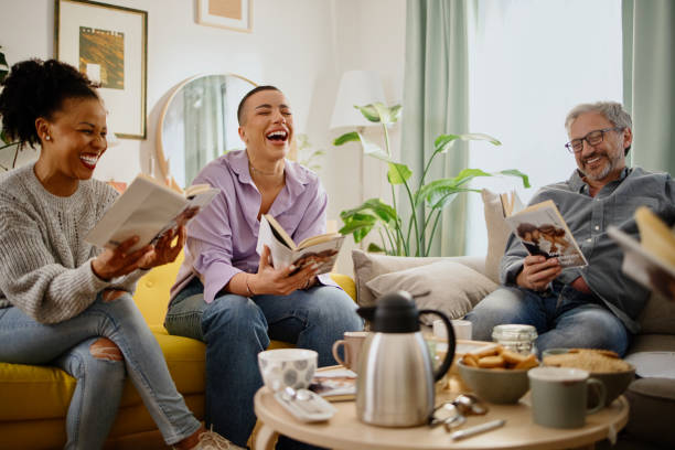 Friends at a Book Club discussing a book together and laughing stock photo
