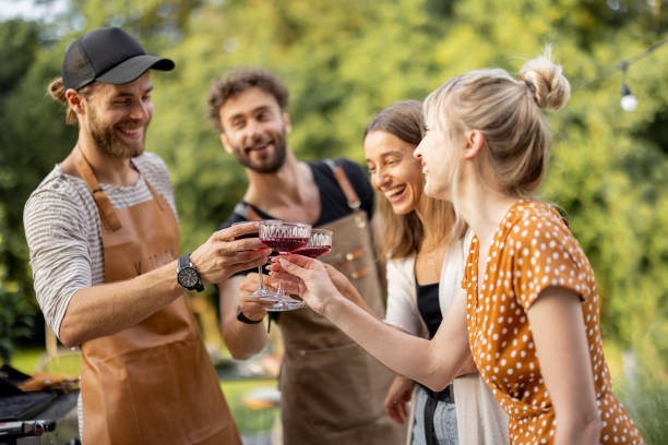 Friends celebrating with alcohol drinks outdoors stock photo