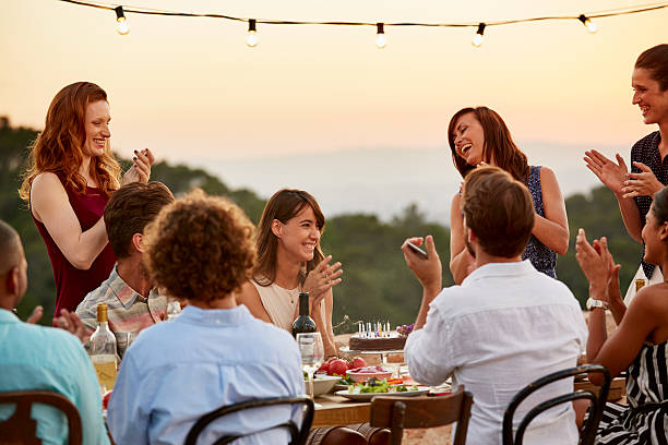 Friends clapping while enjoying dinner party Happy male and female friends clapping while enjoying dinner party happy birthday wine bottle stock pictures, royalty-free photos & images
