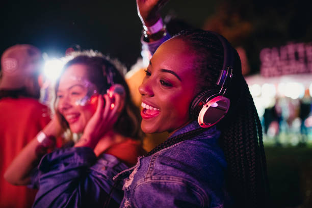 Friends Dancing in a Silent Disco Young women are having fun and dancing in a silent disco at a music festival. disco dancing stock pictures, royalty-free photos & images