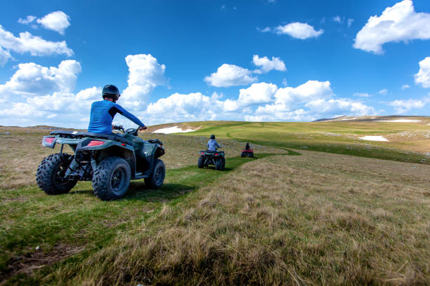 Friends driving off-road with quad bike or ATV and UTV vehicles stock photo