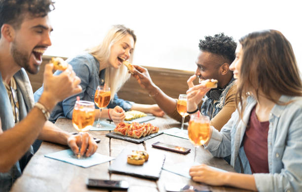 amis mangeant et buvant le spritz au restaurant de bar de cocktail de mode - concept d'amitié avec des jeunes ayant l'amusement avec des boissons et la nourriture sur l'happy hour au pub - foyer sur des tranches de pizza - apéritif photos et images de collection