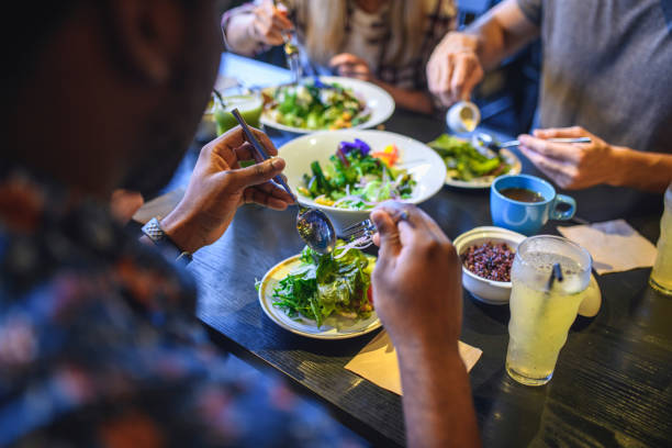 Friends Enjoying Healthy Paleo Food and Drink at a Restaurant stock photo