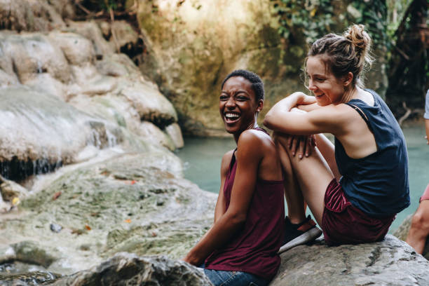 vrienden opknoping door een waterval in de jungle - adventure woman stockfoto's en -beelden