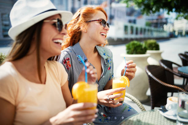 Friends having a great time in cafe. Women smiling and drinking juice and enjoying together Friends having a great time in cafe . Girls smiling and drinking juice and enjoying together. girlfriend stock pictures, royalty-free photos & images