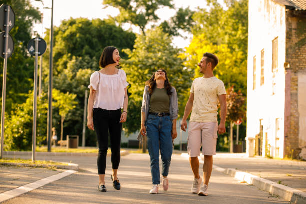 Friends having a laugh while chatting and going on a relaxing walk stock photo