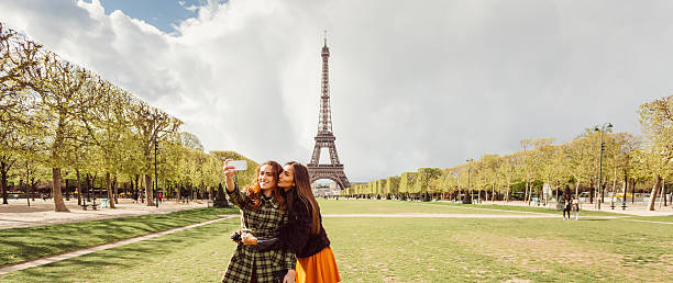 Friends in Paris taking selfie Happy girls taking selfie against the Eiffel tower champ de mars photos stock pictures, royalty-free photos & images