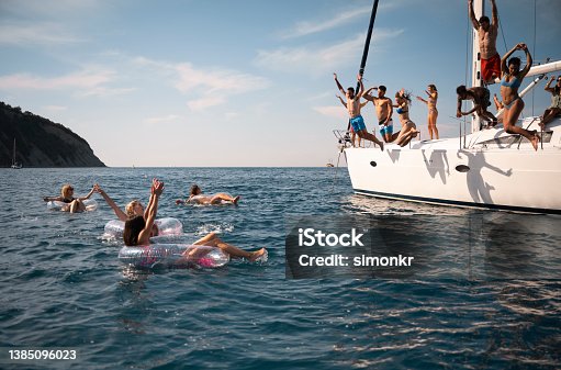 istock Friends jumping in sea 1385096023