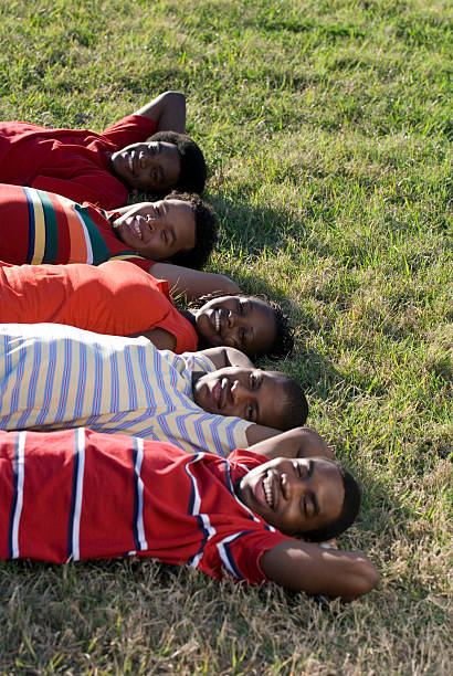 friends lying down in formation - hogeschool rood samen stockfoto's en -beelden