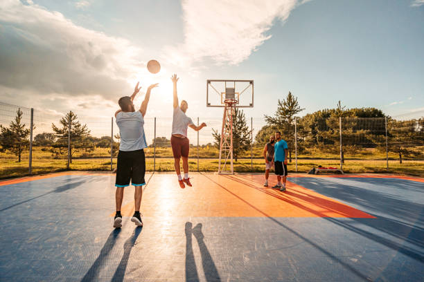Friends Playing Basketball Outdoors stock photo