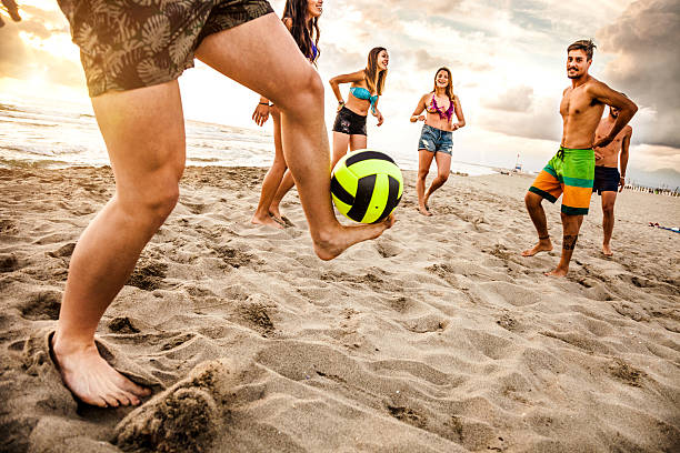amigos a jogar futebol na praia - futebol de praia imagens e fotografias de stock