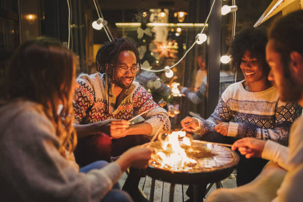 Friends roasting marshmallows at back yard Friends on porch making roasted marshmallow hipster culture photos stock pictures, royalty-free photos & images