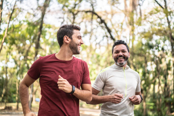 vrienden die samen in een park rennen - alleen mannen stockfoto's en -beelden