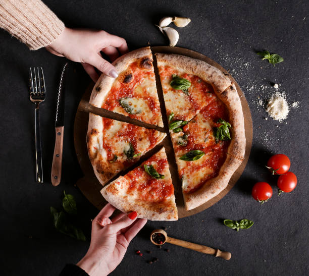 friends sharing a pizza - pizza table imagens e fotografias de stock