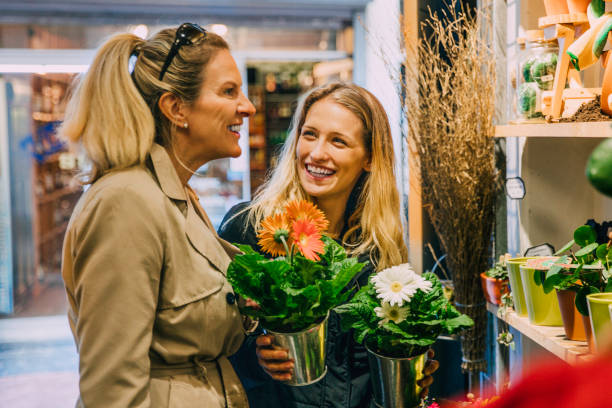 Friends Shopping in Amsterdam Two women shopping for flowers in Amsterdam. small business saturday stock pictures, royalty-free photos & images