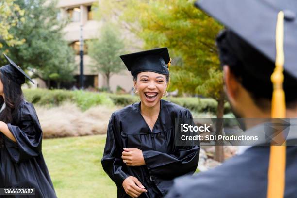 Friends smile and laugh after graduation