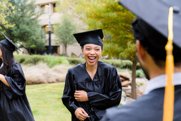 Friends smile and laugh after graduation Young adult friends smile and laugh after the graduation ceremony. universities stock pictures, royalty-free photos & images