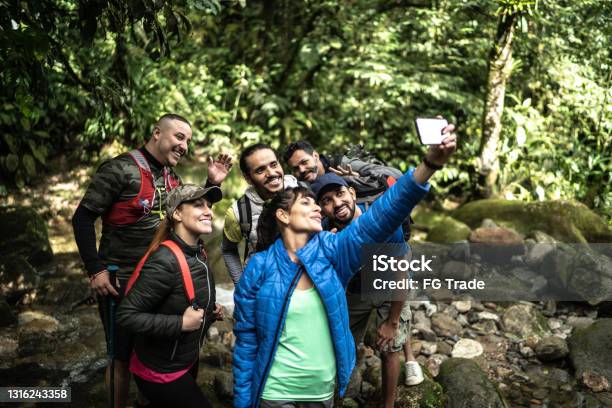 Friends taking a selfie or filming during hiking