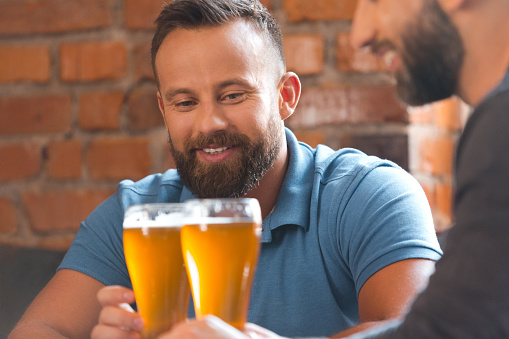 Friends Talking Over Beer In The Pub Stock Photo - Download Image Now ...