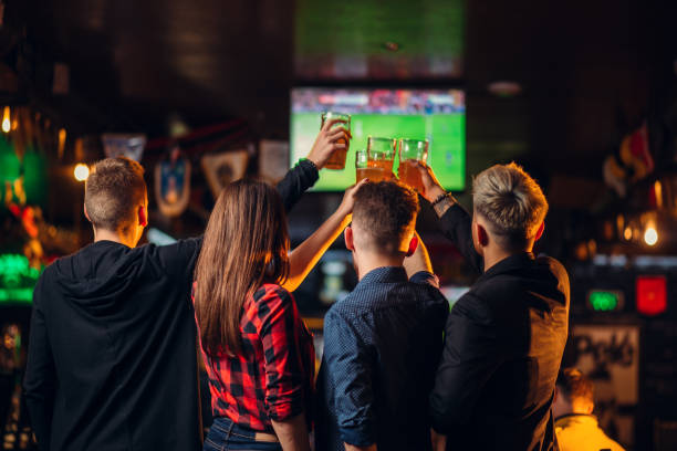 Friends watches football on TV in a sport bar stock photo