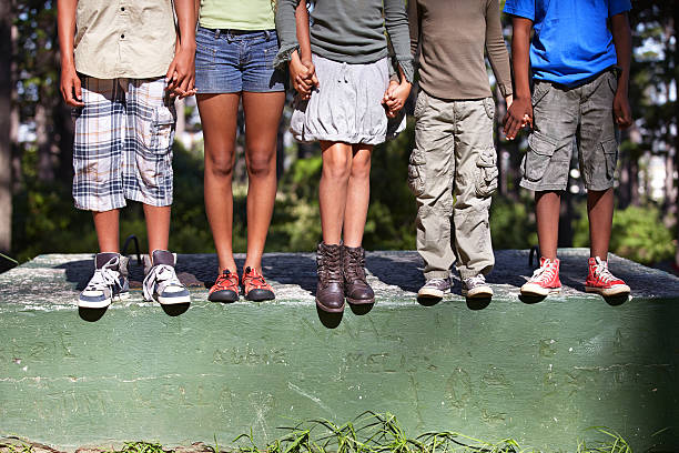 Friendship, diversity and nature Cropped shot of four kids standing on a cement block outdoors children only photos stock pictures, royalty-free photos & images
