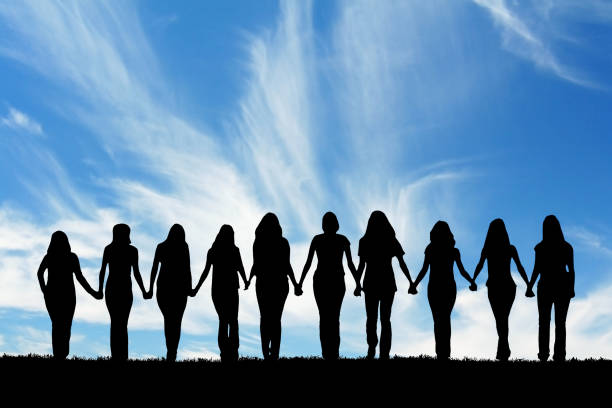 Friendship Silhouette of ten young women, walking hand in hand. adversity photos stock pictures, royalty-free photos & images