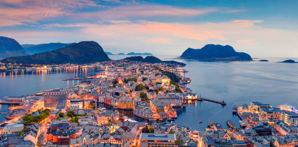 From the bird's eye view of Alesund port town on the west coast of Norway, at the entrance to the Geirangerfjord. Colorful sunset in the Nord. Traveling concept background. stock photo