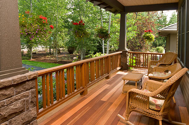 Front deck with wicker chairs This multi colored hardwood front deck, with wicker chairs gives you a beautiful morning garden view.  deck stock pictures, royalty-free photos & images