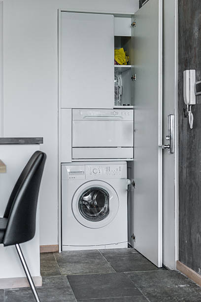 laveuse à chargement frontal avec placard ouvert dans l’intérieur de la maison moderne - programmer machine à laver photos et images de collection