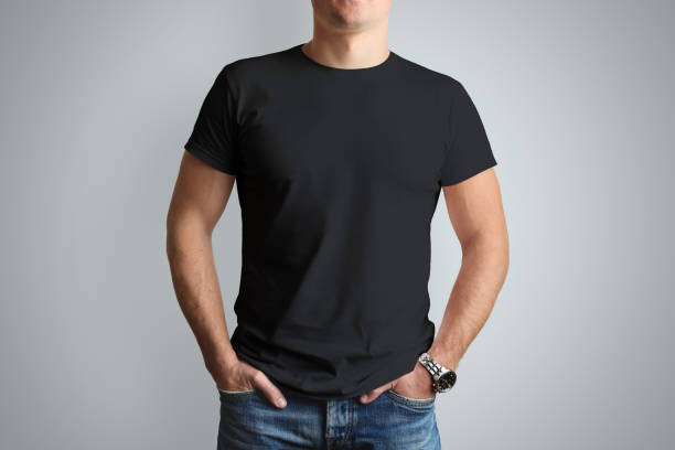 Front mockup black T-shirt on a young  guy isolated on a gray background. stock photo