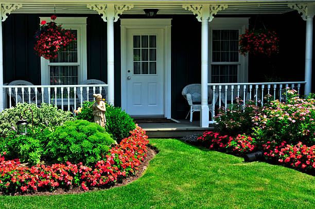 Front porch of house with lawn and border of flowers Landscaped front yard of a house with flowers and green lawn front yard stock pictures, royalty-free photos & images