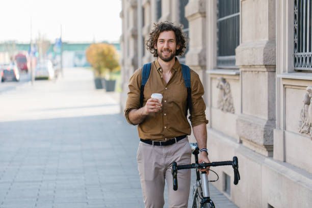 Front view of a handsome young businessman holding a coffee cup stock photo