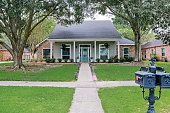 istock A front view of an Acadian renovated home with columns, sidewalks and a colorful front door recently purchased with the changing real estate market 1332179910